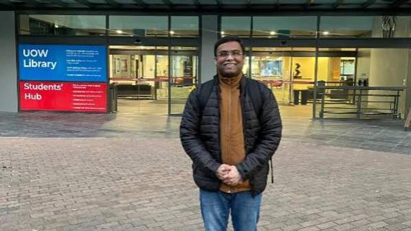 Kushagra, PhD BAL student stands outside the University of Wollongong Library entry