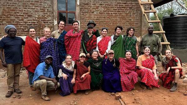 A group of UOW volunteers stand alongside Tanzanian locals