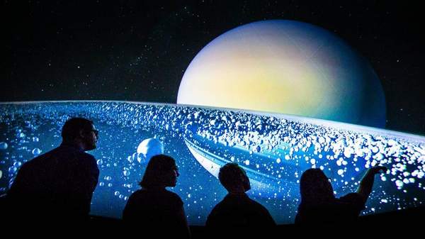 University of Wollongong Science Space Planetarium visitors gazing at the solar system display in the background