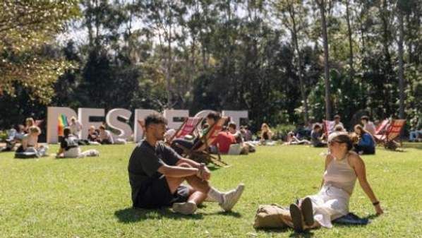 RESPECT letters on lawn with students socialising in foreground