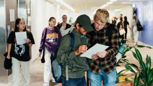 Two students check information during Orientation at UOW Liverpool.