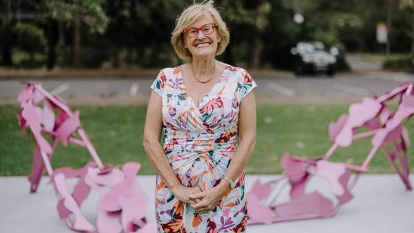 Sculptor Jenny Green in front of Beautopia, two bright pink stilettos made out of steel. Photo: Michael Gray