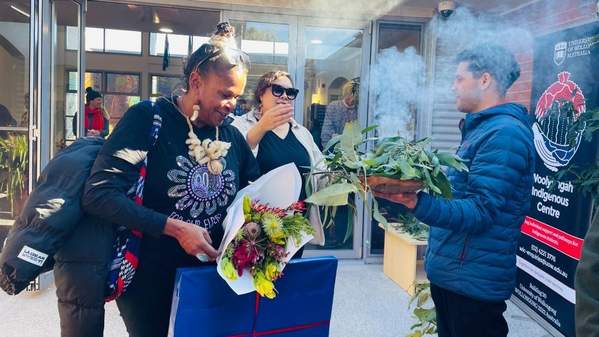 Two people take part in a Smoking Ceremony outside UOW Bega Valley Campus. Photo: Supplied