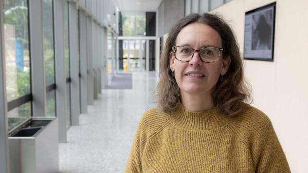 Dr Catherine MacPhail standing in a corridor smiling. Photo: Mark Newsham