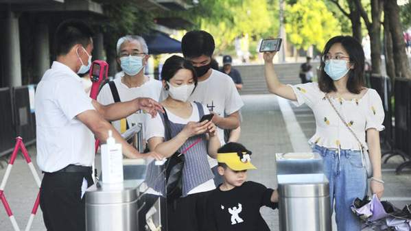 Staff checking people’s green ‘health codes’ at the gate of the entrance to a park in Shanghai. Yang Jianzheng/AP