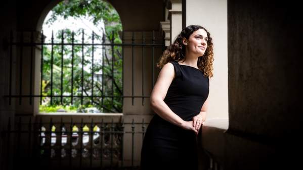 UOW graduate Jamie Coleman, pictured outside a courthouse in Wollongong, wearing a black dress. Photo: Paul Jones