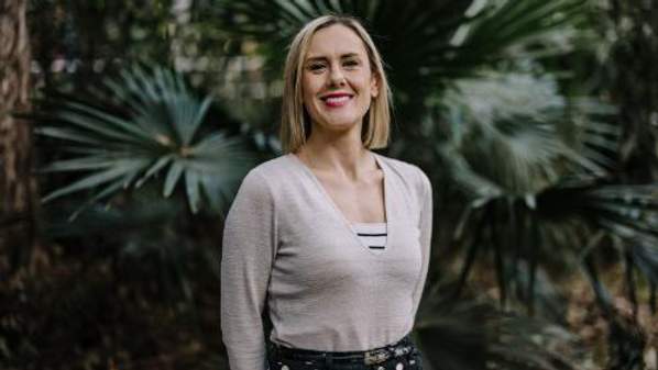 A smiling woman wearing a white shirt