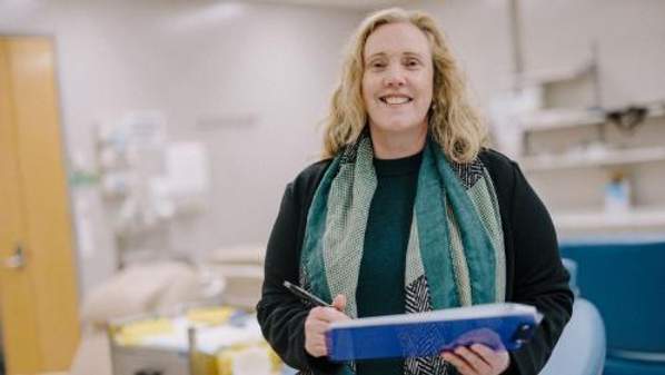 Woman smiling and holding a clipboard