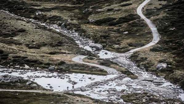 Hikers fording a creek in the Kosciusko National Park.