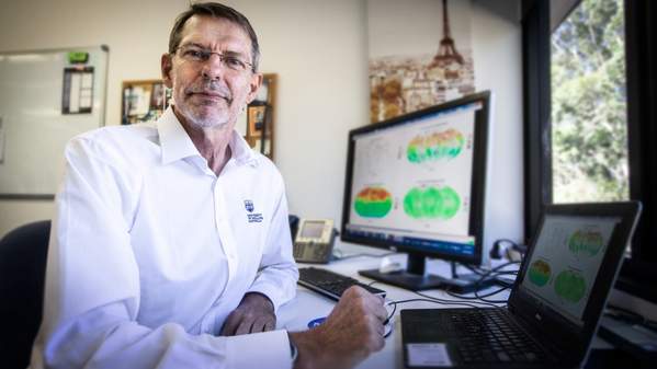 A man sits in front of a computer, which displays infrared graphs and images. Photo: Paul Jones