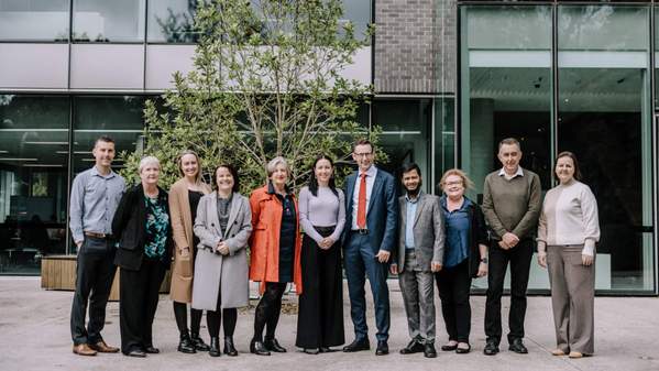 The UOW academics joined by Stephen Jones are outside Building 29. There are 11 people in a row. Photo: Michael Gray