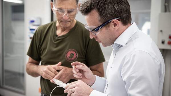 Professor Stephen Beirne looks at a 3D printed item with another researcher looking on. Photo: Paul Jones