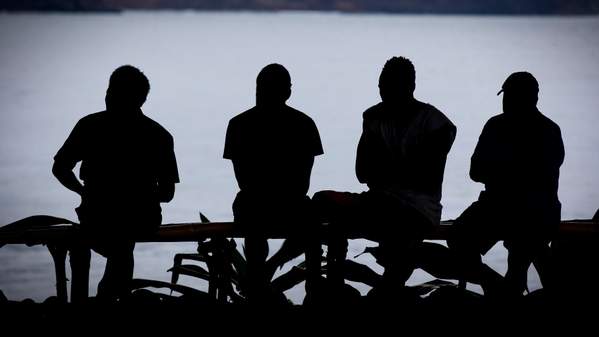 Four men are silhouetted against the ocean in Vanuatu. Photo: Paul Jones