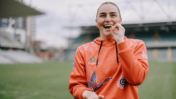 Dragons NRLW player Tara McGrath smiles as she takes a dose of fish oil capsules. Photo: Michael Gray