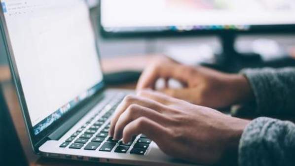 Hands typing on a laptop