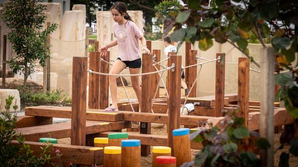 Children use the play equipment at the new All Ages All Abilities playground in ý.