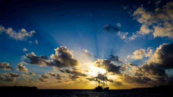 A fishing boat leaves Port Villa at dawn.