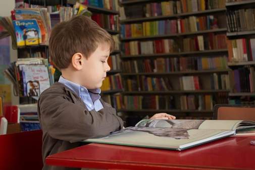 A student reading a book at a desk.
