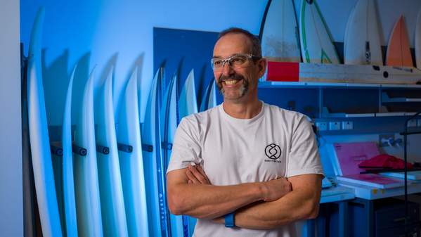 Professor Marc in het Panhuis in the Surf Flex Lab. His arms are crossed and there are surfboards in the background. Photo: Andy Zakeli