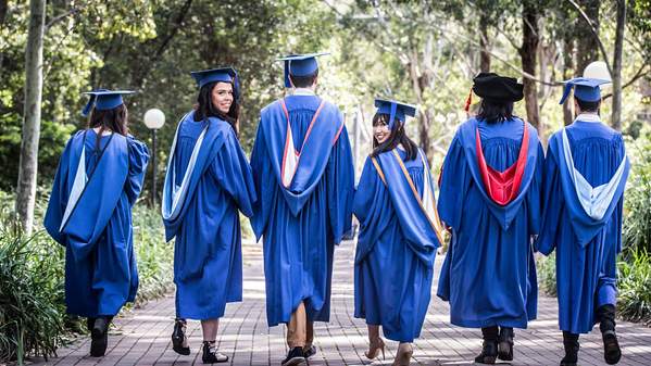 An image of six graduates with their back to the camera, pictured on 51 campus. Photo: Paul Jones