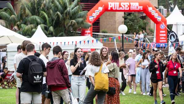 UOW students at Wollongong campus with the big sign of Pulse above