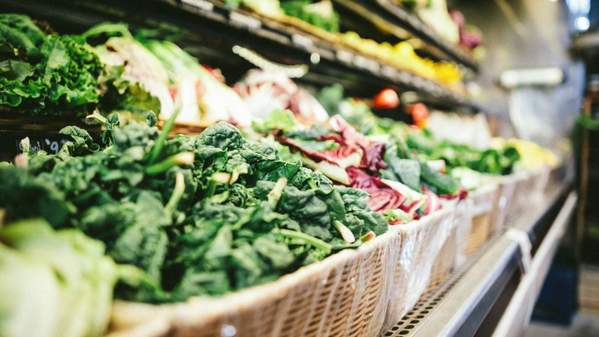 A row of baskets of vegetables lined up in a grocery store. Photo: Unsplash