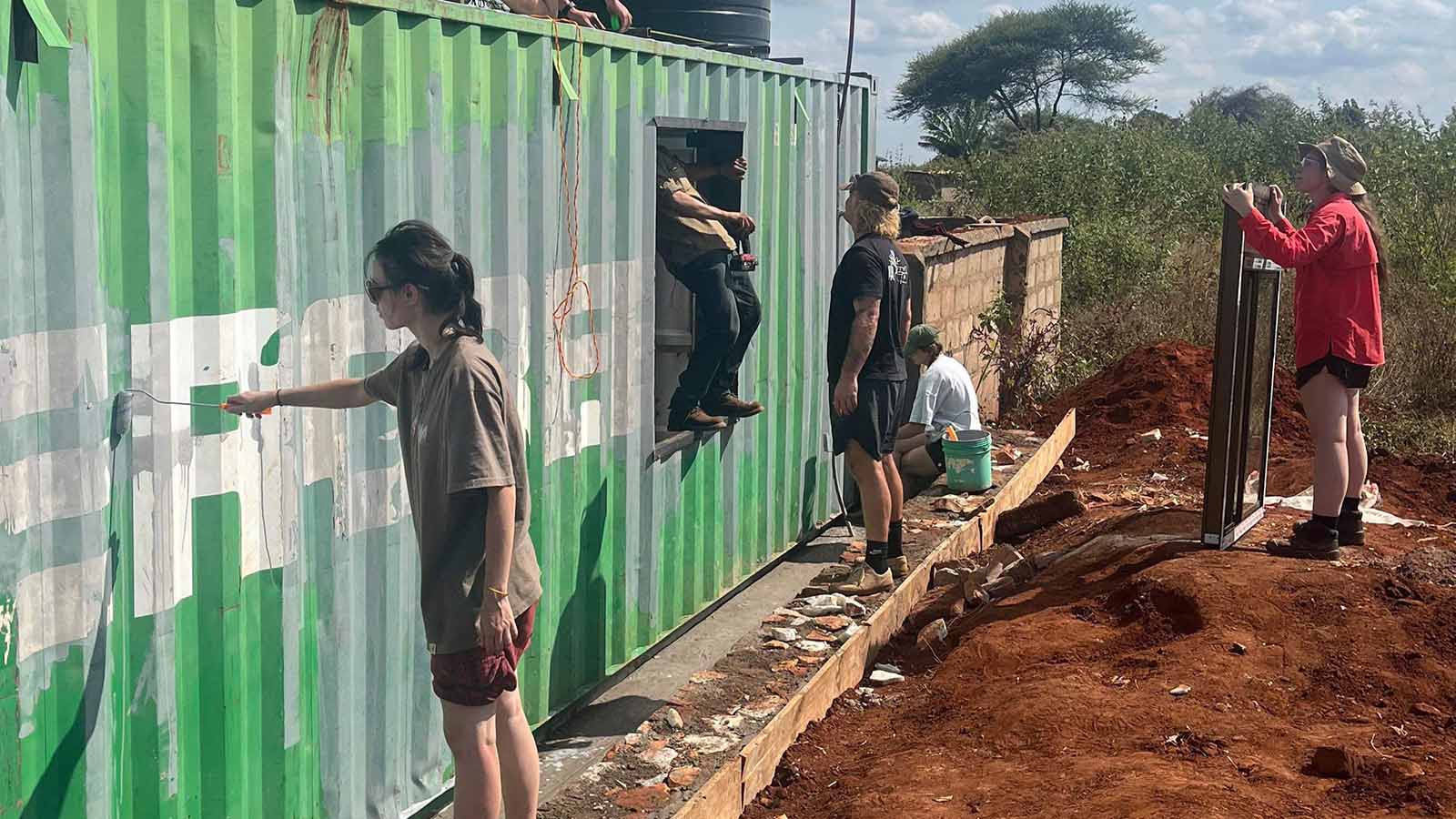 UOW students painting the outside of a classroom at Manyara Primary School.
