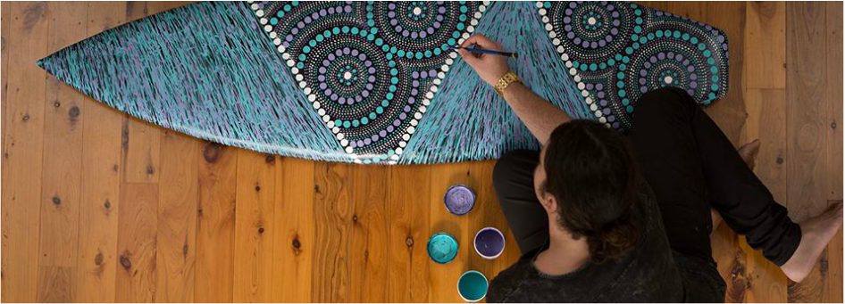 Zach painting on one of his surfboards