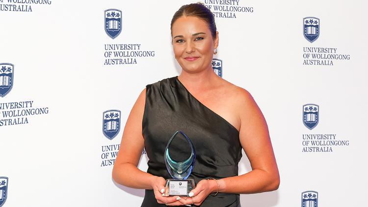 Natalie Matosin is ina lab - she holds a vile up to the light. She is wearing a lab coat and blue surgical gloves