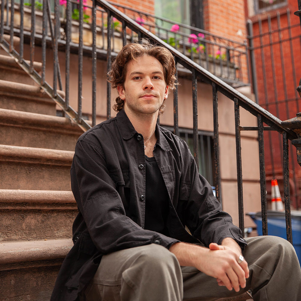 Portrait of Dakota Feirer seated on outdoor stairs.