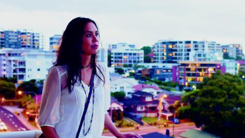 Student on balcony with Wollongong in the background