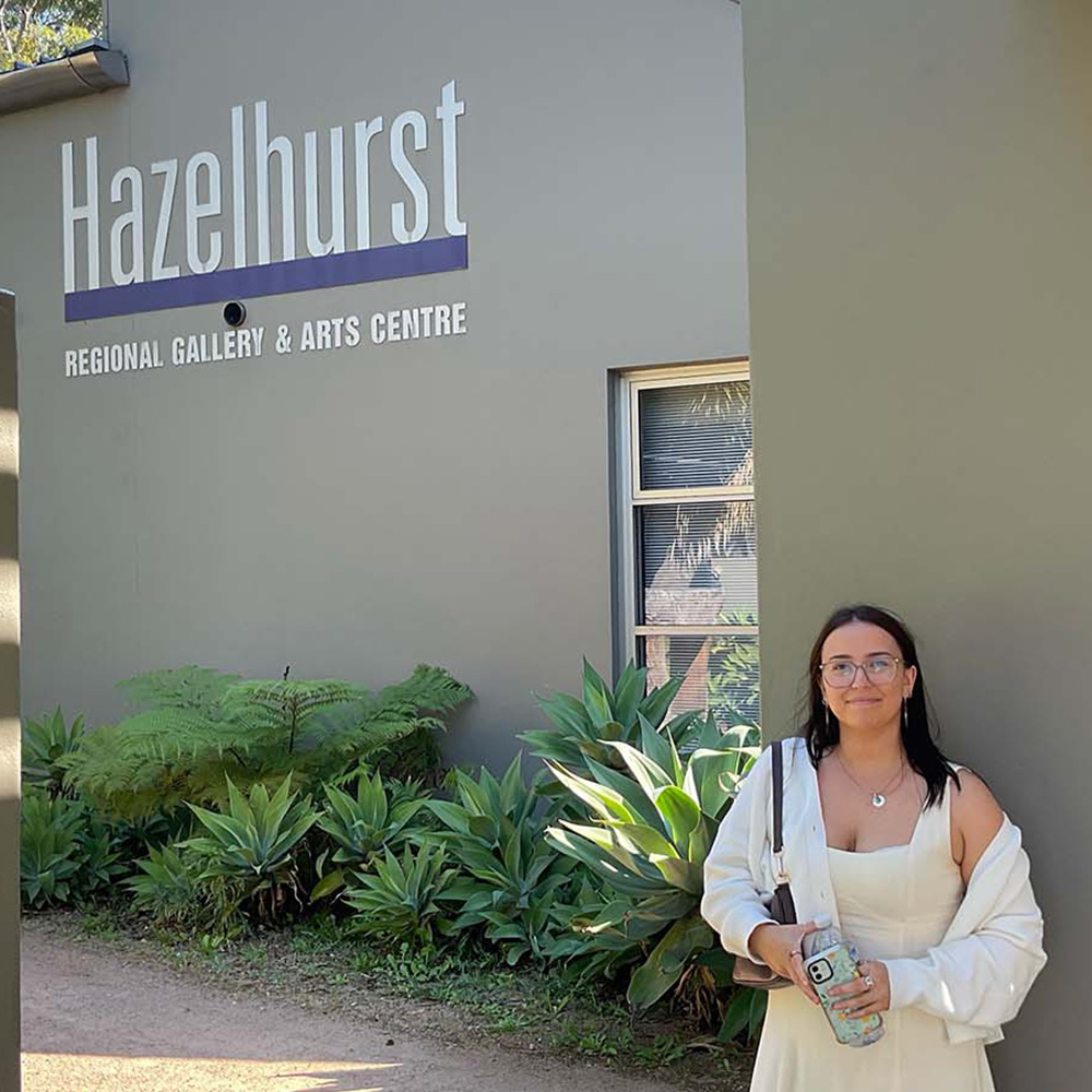 A woman is standing out the front of the Hazelhurst Regional Gallery and Arts Centre