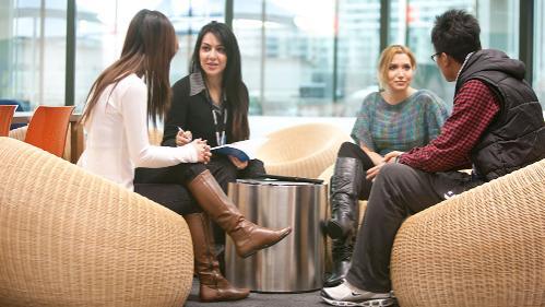 Four people sitting around in discussion-with each other.