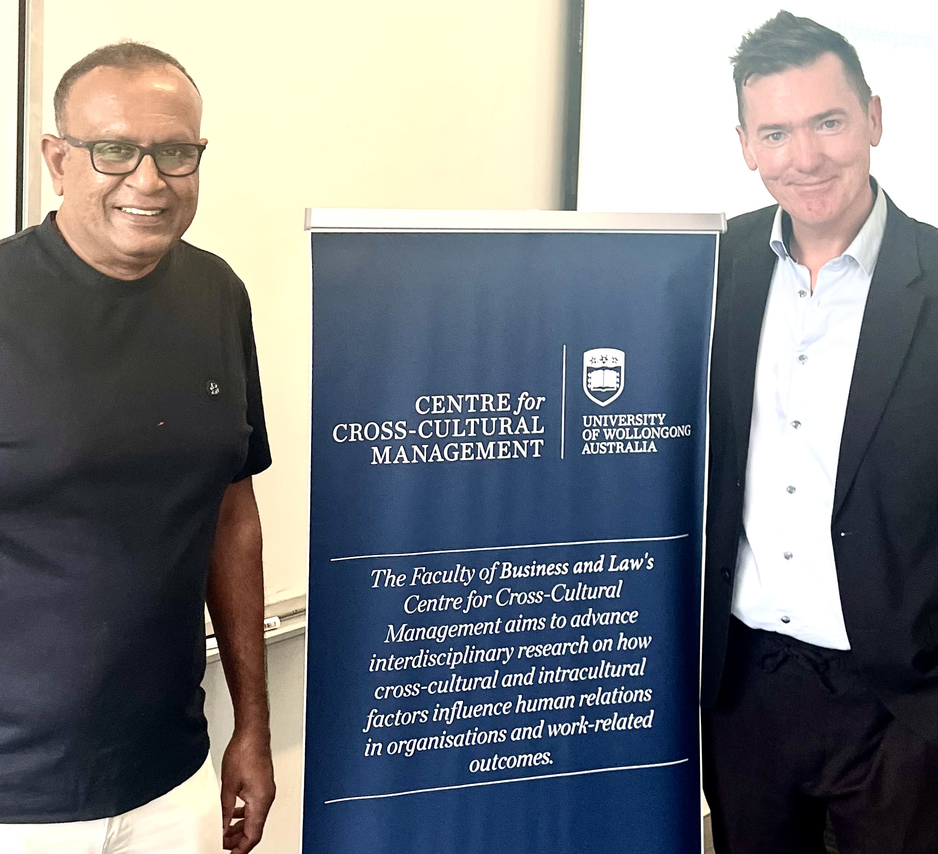 2 men stand alongside CCCM pull up banner