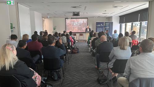 A diverse group of people sitting listening to a presenter