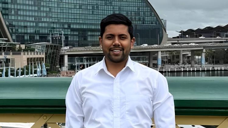 UOW Alumni, Rudra Pratap Singh stands on a pedestrian bridge in Darling Harbour