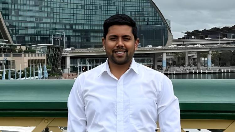 UOW Alumni, Rudra Pratap Singh stands on a pedestrian bridge in Darling Harbour