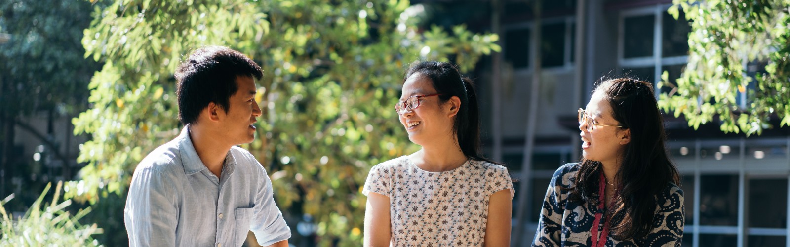 Three international students sitting outside talking