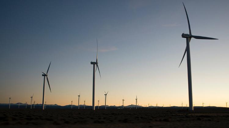 many wind turbines on a dusky back drop