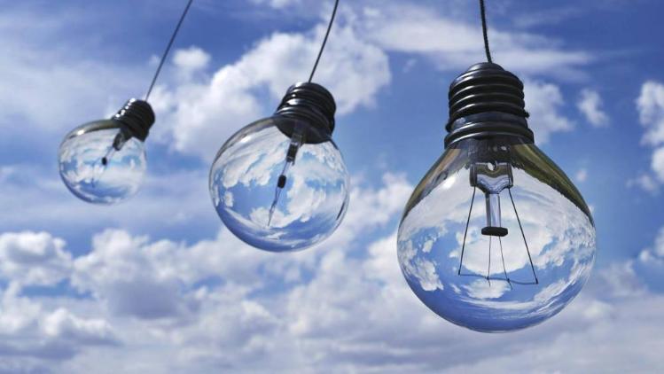 Three light bulbs hung with clouds in background