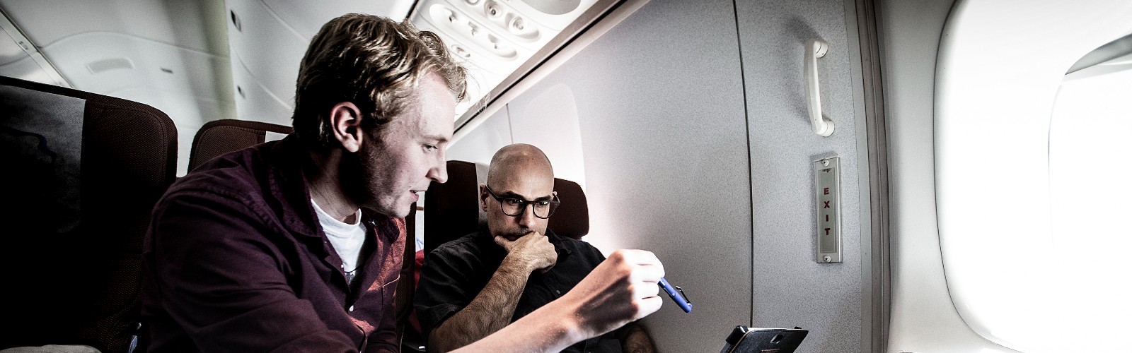 UOW Physics researchers sitting in plane looking over iPad