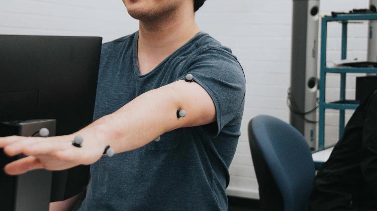 Man holding out arm with nodes attached