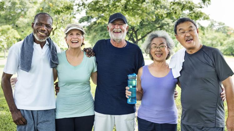 Group of older people standing in front of a tree