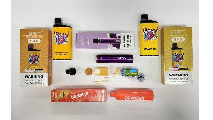 Packaged and unpackaged Vaping products arranged on a white surface.