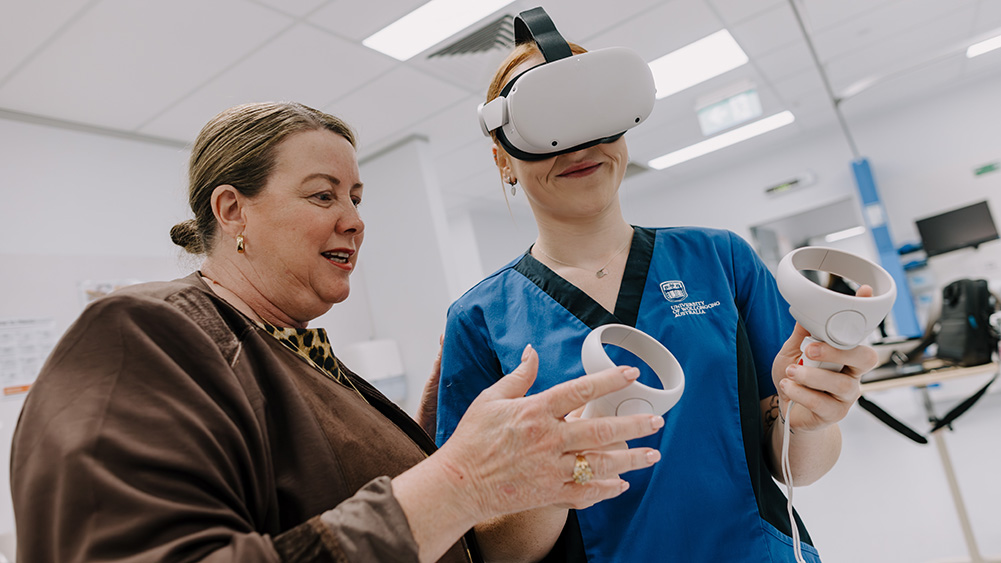 A healthcare professional demonstrates virtual reality equipment in a clinical setting, engaging with a patient.