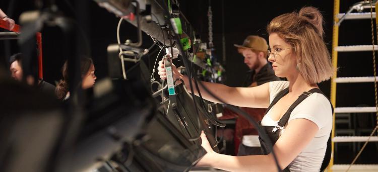 A performance student working on a lighting rig