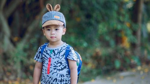 Photo of Boy with Backpack standing on a footpath