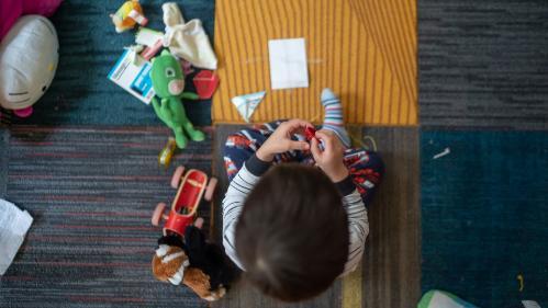 Birds eye view photo of Child playing with toys on mat