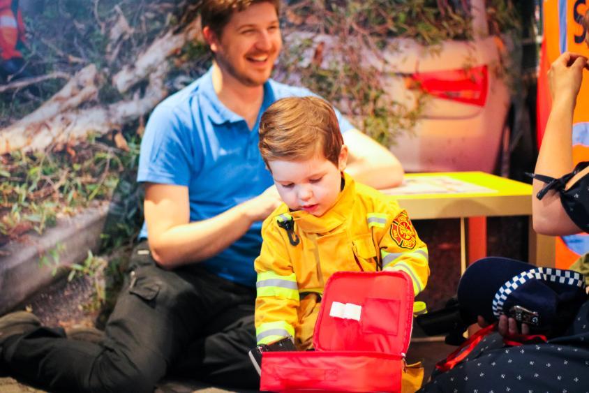 Toddler playing with Emergency equipment at Discovery space