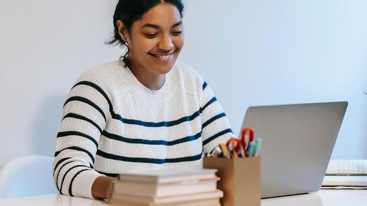 Female student sitting infront of computer smiling